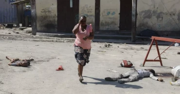 Hundreds of inmates flee after armed gangs storm Haiti's main prison, leaving bodies behind